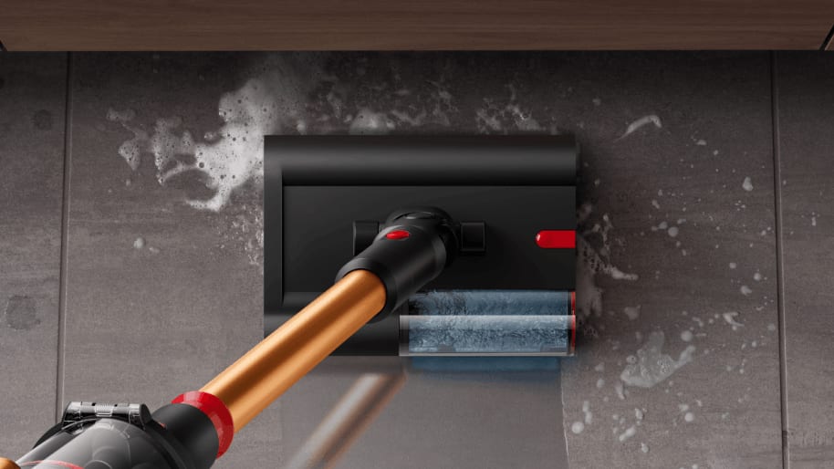 Woman vacuuming living room floor with Dyson vacuum